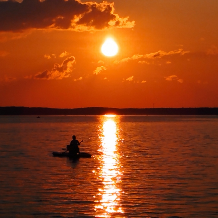 Закат на озере Селигер. Человек в лодке на фоне заката